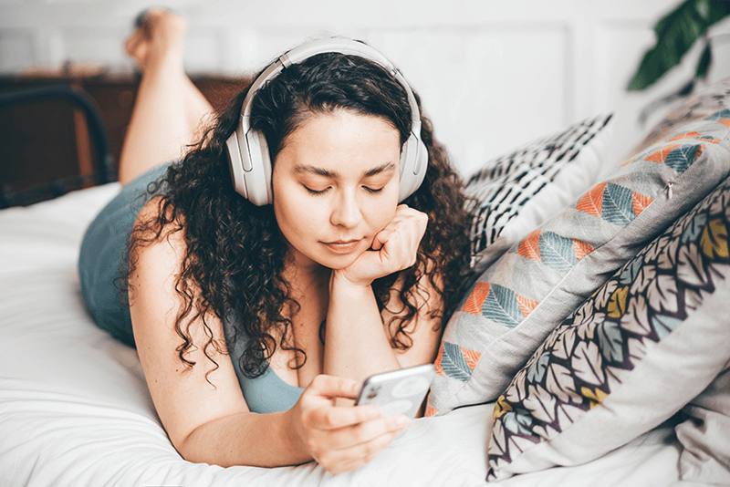mujer escuchando música en la cama